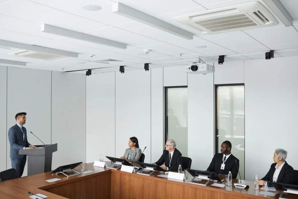 Apresentação formal diante de comitê em sala de conferência